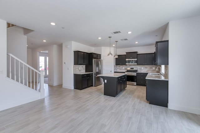 2613 W Mallard, Hanford, CA 93230 - kitchen featuring stainless steel appliances, a sink, a center island, tasteful backsplash, and baseboards