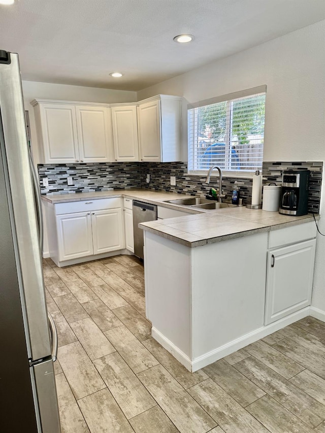 1079 E El Paso Ave, Fresno, CA 93720 - kitchen with stainless steel appliances, a sink, tasteful backsplash, white cabinets, and light countertops