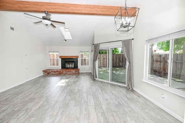 1079 E El Paso Ave, Fresno, CA 93720 - unfurnished living room with a fireplace with raised hearth, ceiling fan, beam ceiling, healthy amount of natural light, and wood finished floors