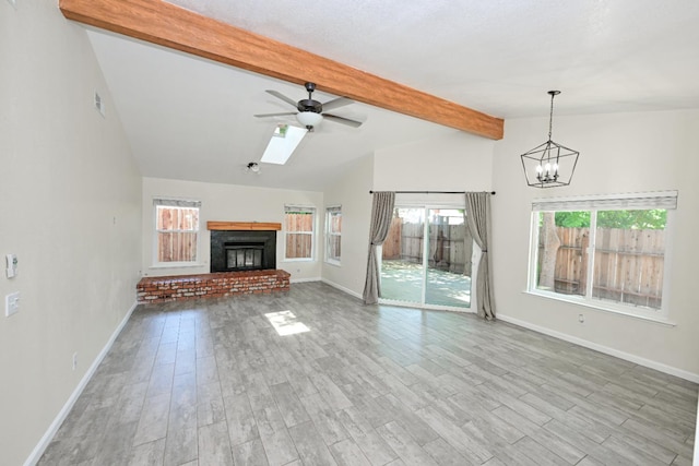 1079 E El Paso Ave, Fresno, CA 93720 - unfurnished living room with a ceiling fan, wood finished floors, a glass covered fireplace, and a chandelier