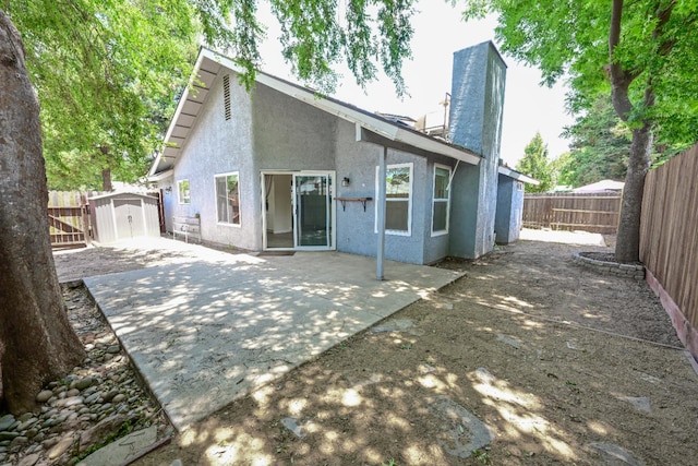 1079 E El Paso Ave, Fresno, CA 93720 - back of property featuring a storage unit, a chimney, stucco siding, a patio area, and a fenced backyard