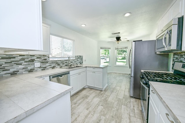 1079 E El Paso Ave, Fresno, CA 93720 - kitchen with appliances with stainless steel finishes, a peninsula, white cabinets, backsplash, and recessed lighting