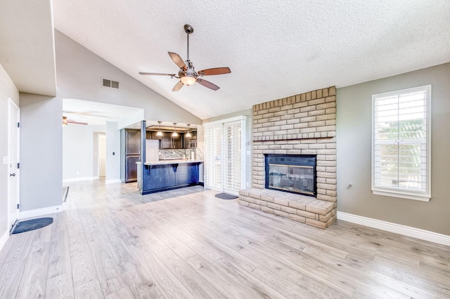 6211 N Cleo Ave, Fresno, CA 93722 - unfurnished living room with ceiling fan, a textured ceiling, baseboards, light wood-style floors, and lofted ceiling