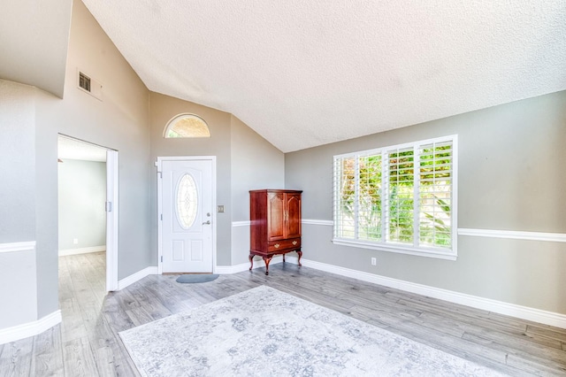 6211 N Cleo Ave, Fresno, CA 93722 - entrance foyer featuring light wood finished floors, vaulted ceiling, a textured ceiling, and baseboards