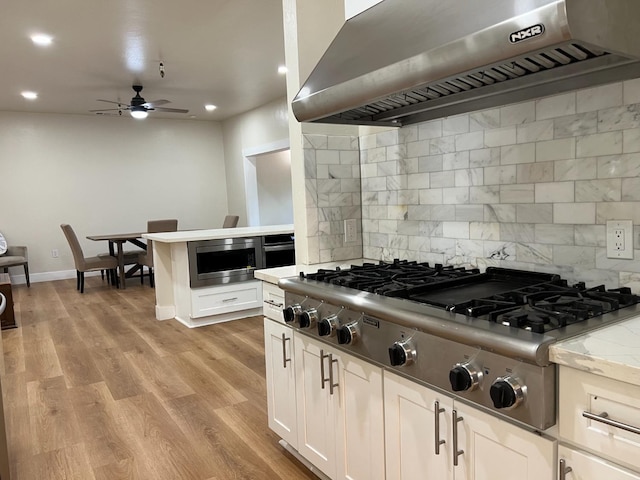 7013 N Maroa Ave, Pinedale, CA 93650 - kitchen with ventilation hood, stainless steel appliances, ceiling fan, decorative backsplash, and light wood-style flooring