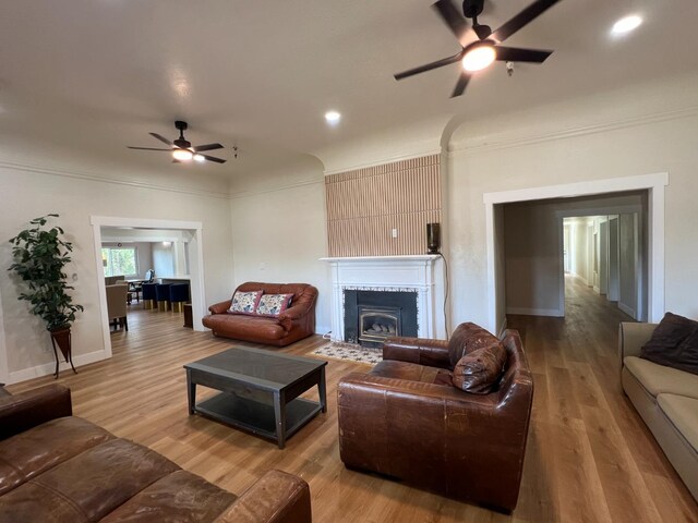 7013 N Maroa Ave, Pinedale, CA 93650 - living room featuring ceiling fan, a fireplace, wood finished floors, baseboards, and crown molding