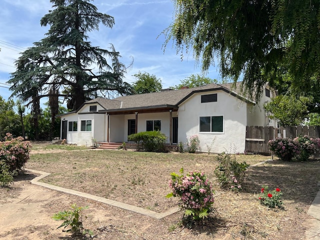 7013 N Maroa Ave, Pinedale, CA 93650 - view of front facade featuring fence, stucco siding, and roof with shingles