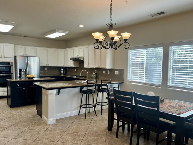 2604 W Taylor, Visalia, CA 93291 - kitchen with appliances with stainless steel finishes, dark countertops, under cabinet range hood, light tile patterned floors, and recessed lighting