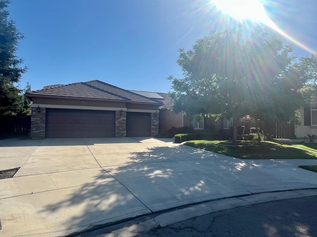 2604 W Taylor, Visalia, CA 93291 - view of front of property with stone siding, driveway, a garage, a tile roof, and a front lawn