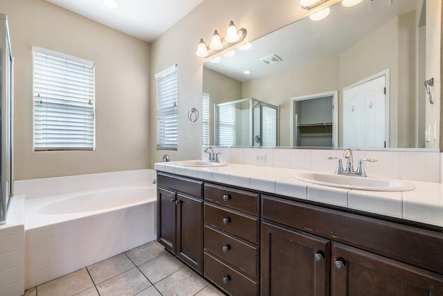 full bathroom featuring a shower stall, a garden tub, tile patterned flooring, and double vanity
