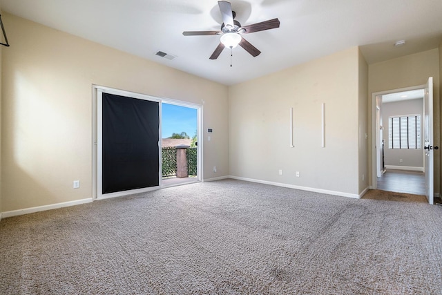 carpeted empty room featuring a ceiling fan, healthy amount of natural light, baseboards, and a smoke detector