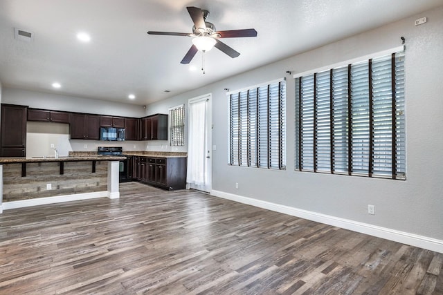 kitchen with black microwave, ceiling fan, dark wood-style flooring, dark brown cabinetry, and baseboards