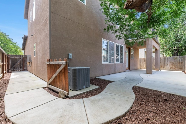 view of property exterior featuring central AC, a patio, a gate, and a fenced backyard