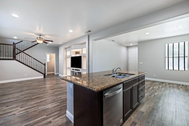 kitchen with stainless steel dishwasher, open floor plan, a sink, dark wood-type flooring, and baseboards