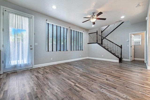 unfurnished living room with a ceiling fan, wood finished floors, stairs, baseboards, and recessed lighting
