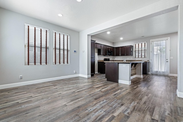 kitchen featuring dark wood-style flooring, recessed lighting, dark brown cabinets, and open floor plan