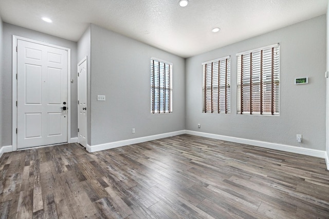 foyer with plenty of natural light, wood finished floors, baseboards, and recessed lighting