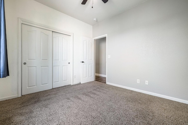 unfurnished bedroom with carpet flooring, a closet, baseboards, and a ceiling fan