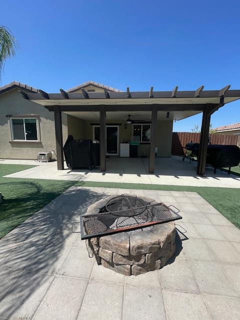 290 Cabrillo Dr, Coalinga, CA 93210 - rear view of house featuring an outdoor fire pit, a patio area, fence, ceiling fan, and stucco siding