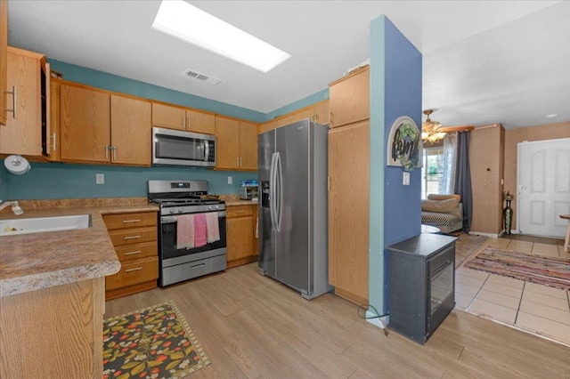 1601 El Paso, Dinuba, CA 93618 - kitchen featuring appliances with stainless steel finishes, a sink, light wood finished floors, and light countertops