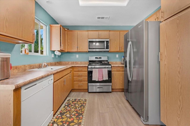 1601 El Paso, Dinuba, CA 93618 - kitchen featuring appliances with stainless steel finishes, light wood-style floors, a sink, light countertops, and light brown cabinetry