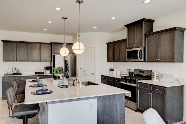 1173 Maclure Ave W, Madera, CA 93636 - kitchen featuring appliances with stainless steel finishes, a sink, recessed lighting, a center island with sink, and dark brown cabinets
