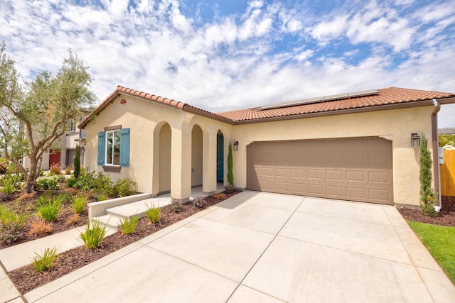 1173 Maclure Ave W, Madera, CA 93636 - mediterranean / spanish home with stucco siding, solar panels, concrete driveway, an attached garage, and a tile roof