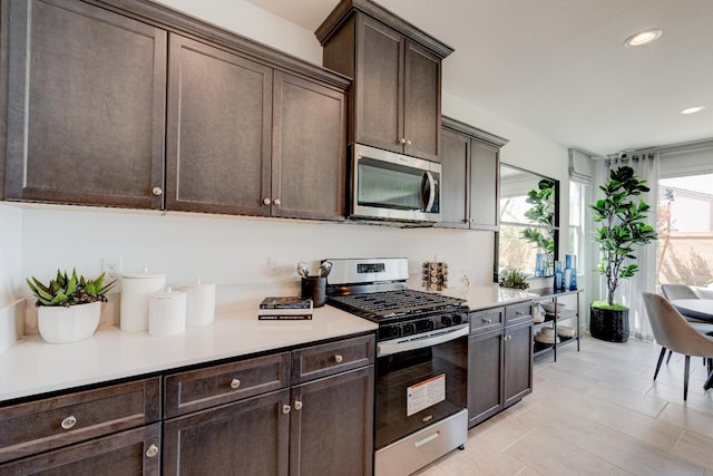 1173 Maclure Ave W, Madera, CA 93636 - kitchen with appliances with stainless steel finishes, dark brown cabinets, recessed lighting, light countertops, and light tile patterned floors