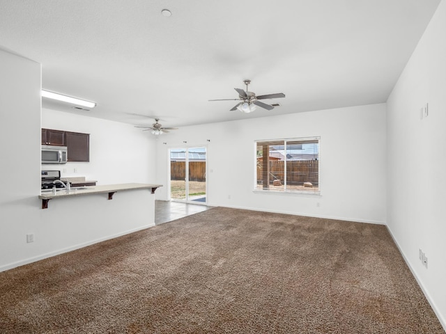 1585 Dallas St, Dinuba, CA 93618 - unfurnished living room with dark carpet, a ceiling fan, and baseboards
