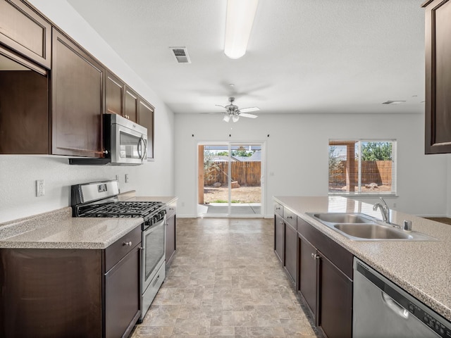 1585 Dallas St, Dinuba, CA 93618 - kitchen featuring appliances with stainless steel finishes, a sink, dark brown cabinets, and a ceiling fan
