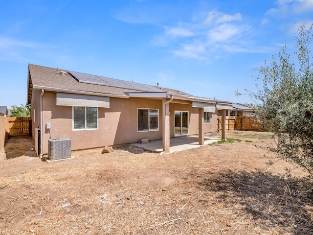 1585 Dallas St, Dinuba, CA 93618 - back of property with a fenced backyard, stucco siding, roof mounted solar panels, and central air condition unit