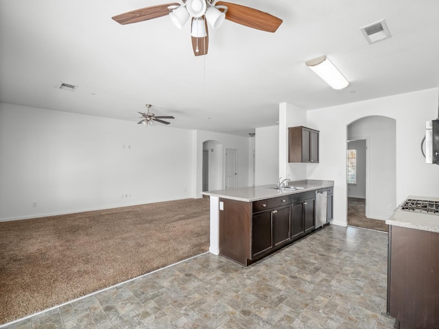 1585 Dallas St, Dinuba, CA 93618 - kitchen featuring arched walkways, ceiling fan, a sink, dark brown cabinetry, and light carpet