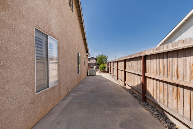 view of home's exterior with stucco siding, a fenced backyard, and a patio area