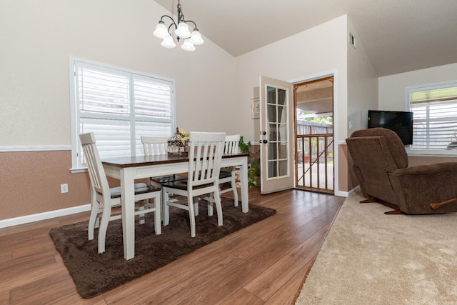 dining room with vaulted ceiling, a chandelier, wood finished floors, and baseboards