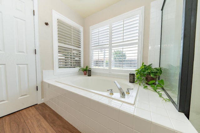 full bath featuring a bath and wood finished floors