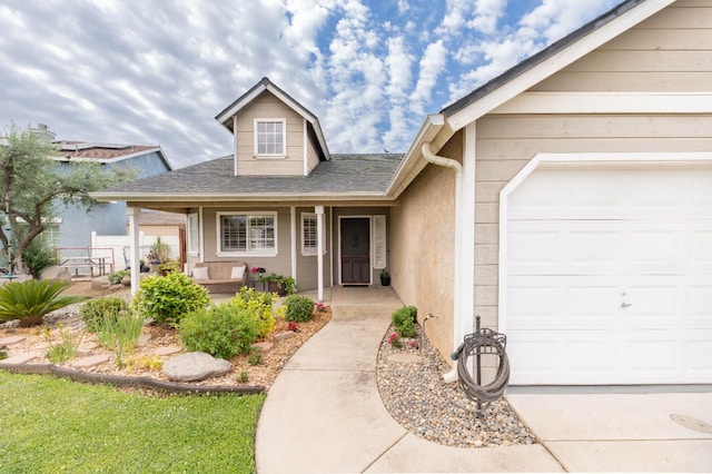 view of front of house with an attached garage, a porch, and a shingled roof