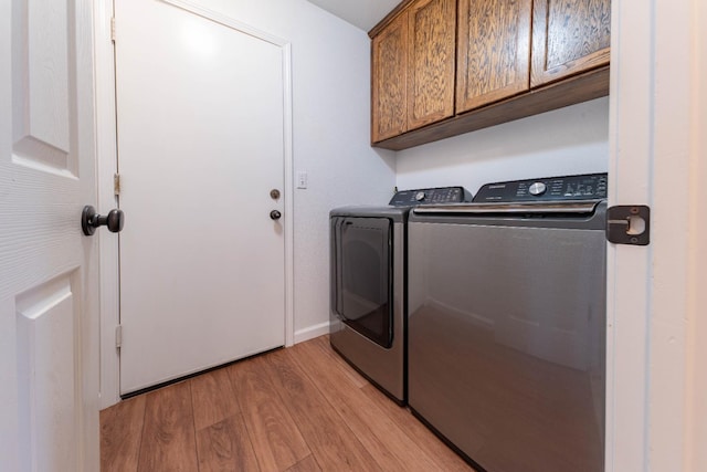 washroom with washer and clothes dryer, cabinet space, light wood-style flooring, and baseboards