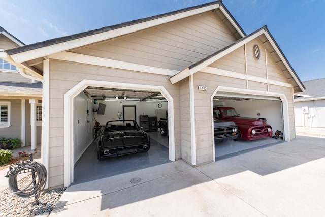 view of car parking with concrete driveway and an attached garage