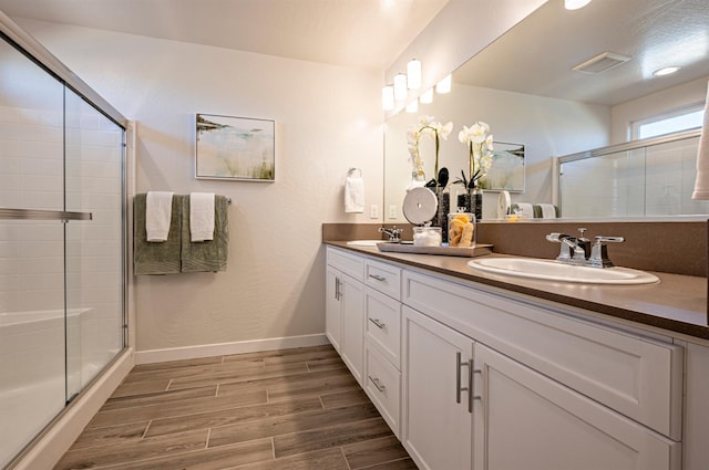 1161 Maclure Ave W, Madera, CA 93636 - full bathroom featuring a shower stall, wood finished floors, double vanity, and baseboards