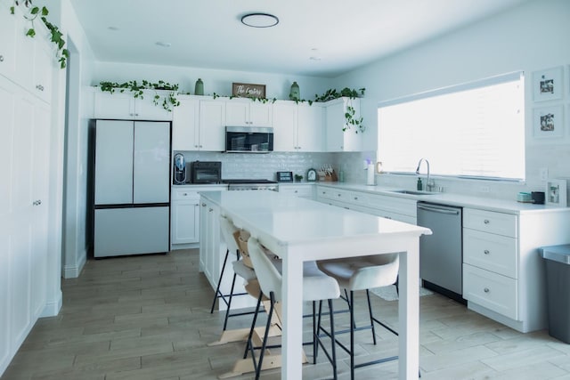 324 Sunset Dr S, Madera, CA 93636 - kitchen with appliances with stainless steel finishes, a sink, white cabinetry, and backsplash