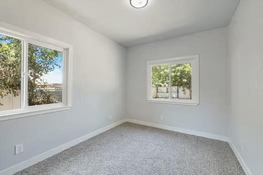 705 Poplar, Fresno, CA 93728 - empty room featuring healthy amount of natural light, carpet floors, and baseboards