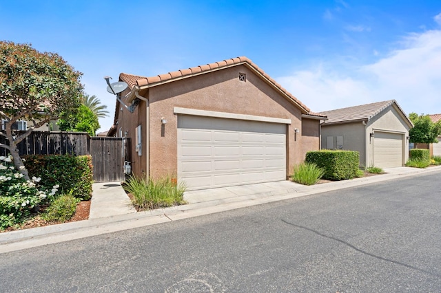3942 Harlan Ranch Blvd, Clovis, CA 93619 - view of front of house with stucco siding, a tile roof, and an attached garage