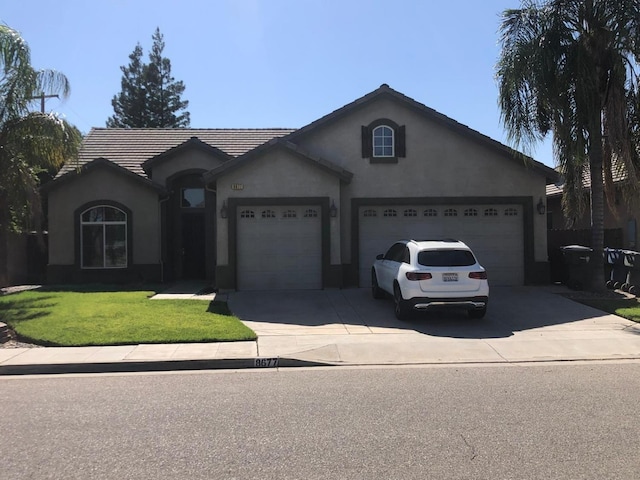 8677 N John Albert Ave, Fresno, CA 93720 - ranch-style home with an attached garage, concrete driveway, a front lawn, and stucco siding