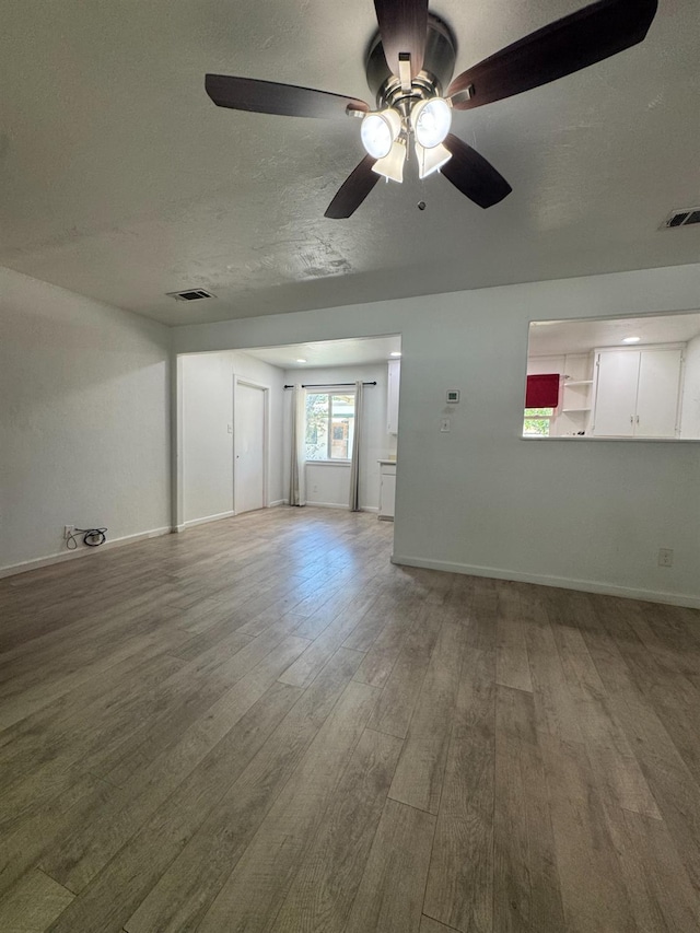 445 Yale, Coalinga, CA 93210 - unfurnished living room with wood finished floors, a ceiling fan, baseboards, and a textured ceiling