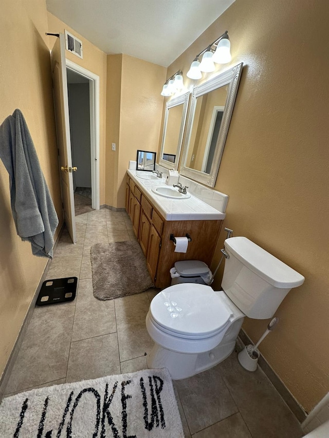 5838 W Fallon Ave, Fresno, CA 93722 - bathroom featuring tile patterned flooring, toilet, baseboards, and double vanity