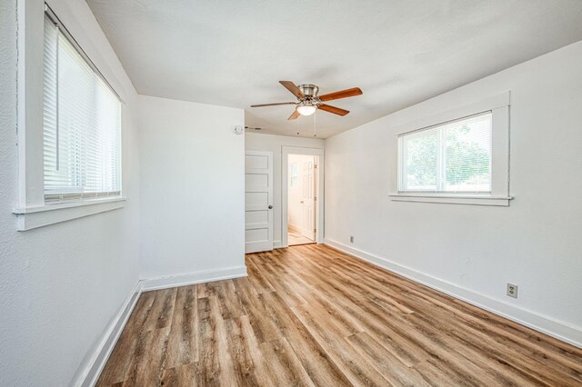 1010 N Ferger Ave, Fresno, CA 93728 - unfurnished bedroom featuring baseboards, wood finished floors, a ceiling fan, and connected bathroom