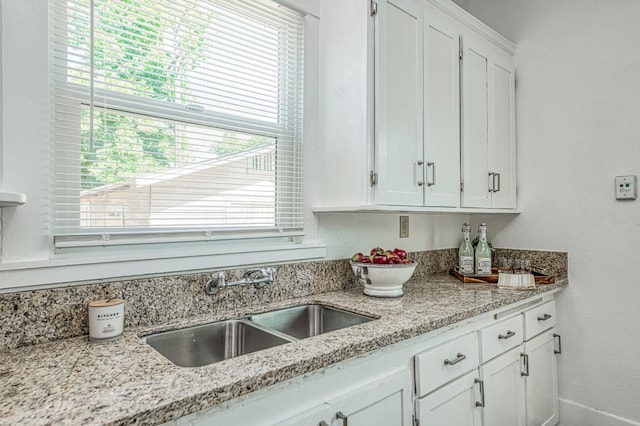 1010 N Ferger Ave, Fresno, CA 93728 - kitchen featuring healthy amount of natural light, a sink, white cabinets, and light stone counters