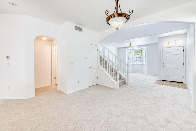83 W Bohemia Ln, Clovis, CA 93619 - unfurnished living room with arched walkways, carpet floors, a ceiling fan, stairs, and baseboards