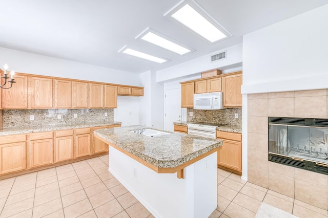 83 W Bohemia Ln, Clovis, CA 93619 - kitchen with a sink, white appliances, light tile patterned flooring, tasteful backsplash, and a kitchen island with sink