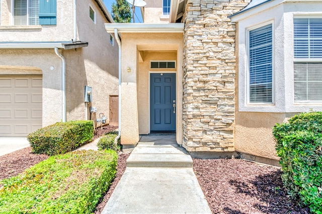 83 W Bohemia Ln, Clovis, CA 93619 - property entrance with stone siding, stucco siding, and a garage
